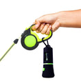 Load image into Gallery viewer, Hand holding a dog leash with an attached LED poop bag dispenser for safe nighttime walks.