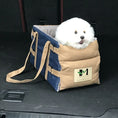 Load image into Gallery viewer, Plush white dog sitting comfortably in a stylish tan and blue car seat for safe travel.